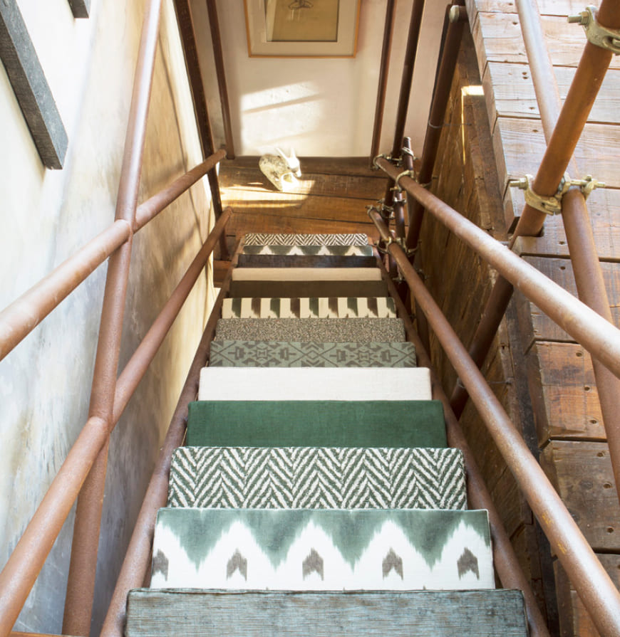 vista de escaleras de metal con escalones tapizados con telas geométricas, étnicas y lisas en tonos verdes