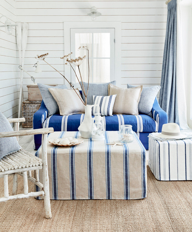 salón mediterráneo tapizado con tejidos de rayas y lisos en tonos natuales y azules