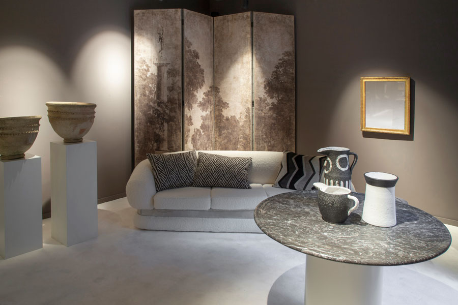 espacio con sofá de tono natural, biombo, cojines y piezas de arte en tonos neutros decorado por Mestizo by Gancedo