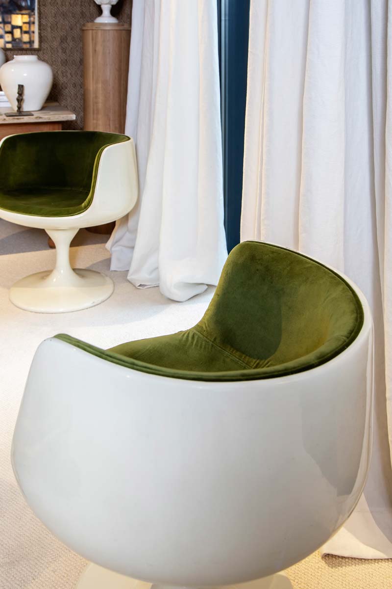 detalle de cortina beige y sillones tapizados de terciopelo verde