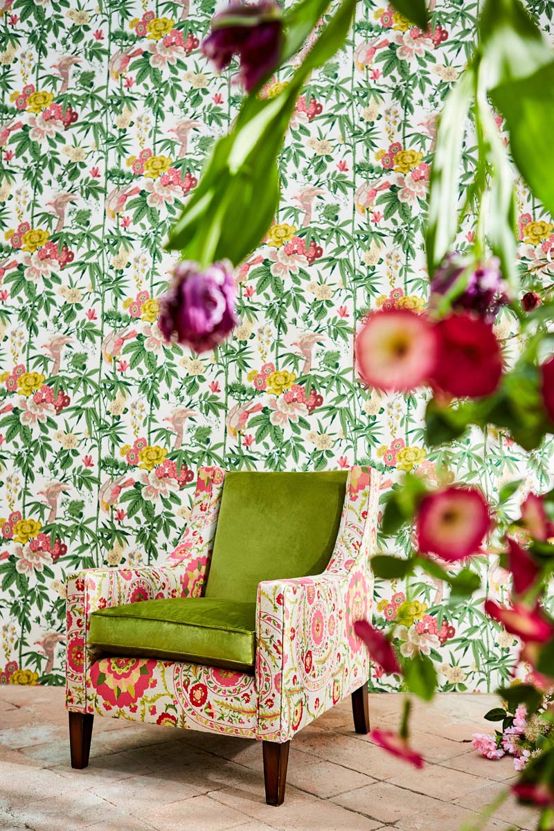 sillon de flores con liso verde en los cojines y papel pintado con motivos vegetales