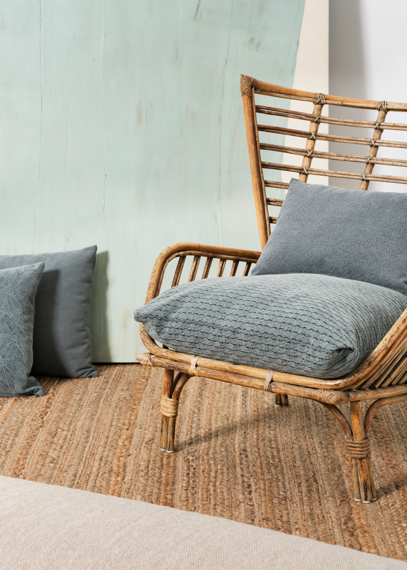 Rincón con sillón de bambú y alfombra de fibra natural