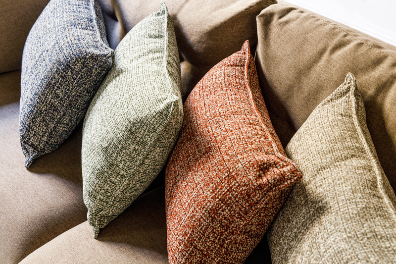 Cojines de distintos colores de Gancedo animando sofá crudo