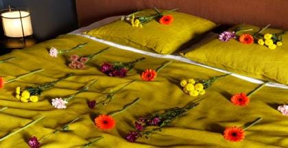 tejidos lino natural en una cama de matrimonio adornados con flores