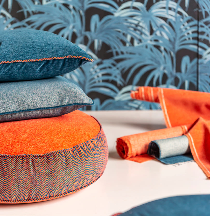 detalle de cojines tapizados con telas en zigzag con detalles en los vivos de tonos azul y rojo