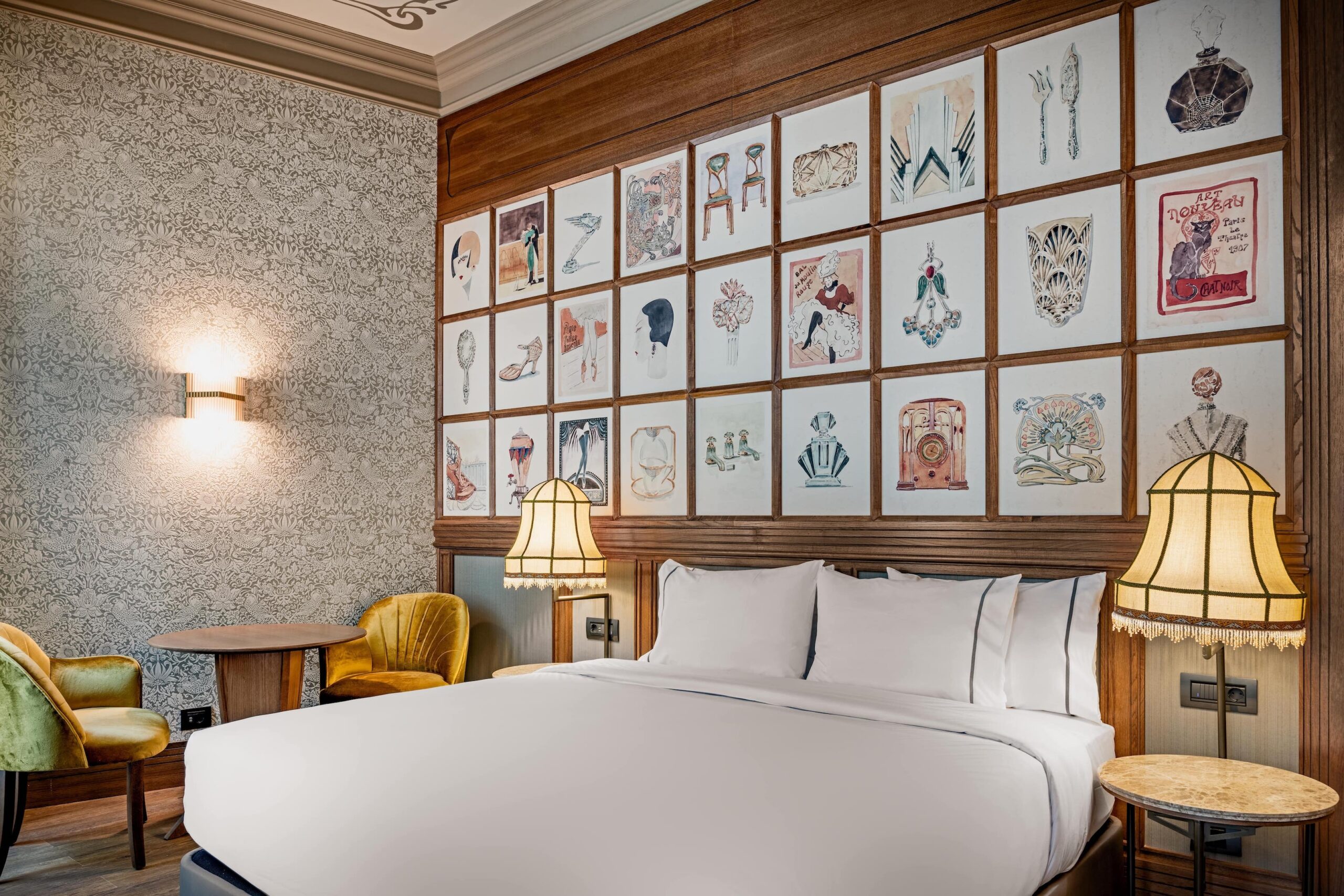 habitación de hotel con papel pintado con motivos vegetales y lámparas de mesilla con pasamaneria